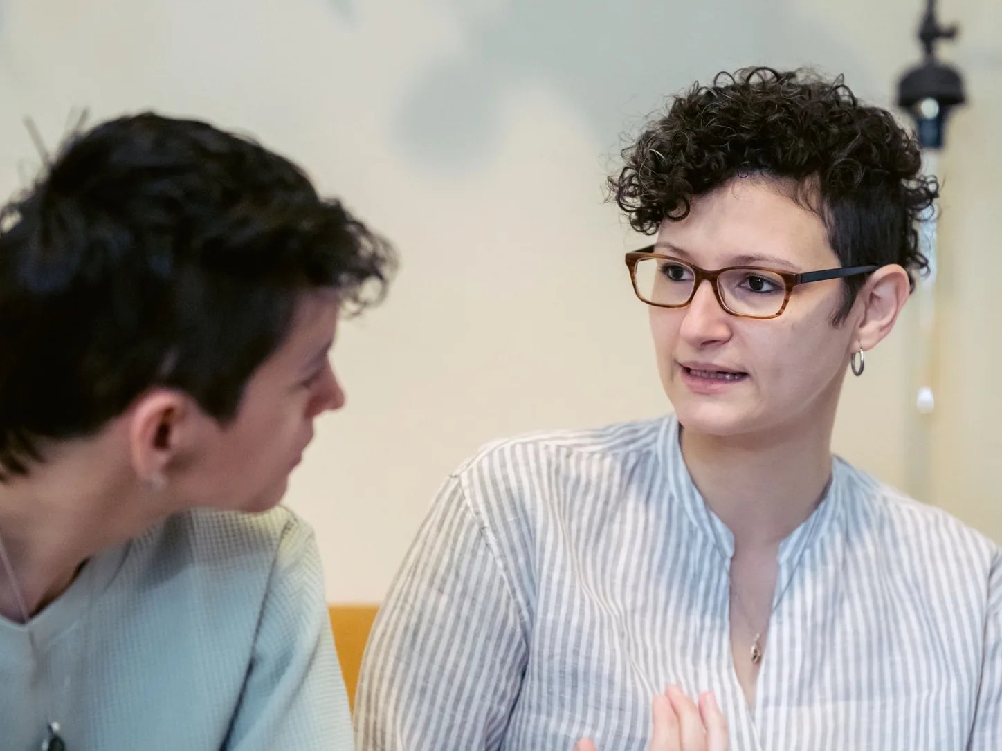 Dwie osoby uważnie rozmawiają w spokojnym wnętrzu